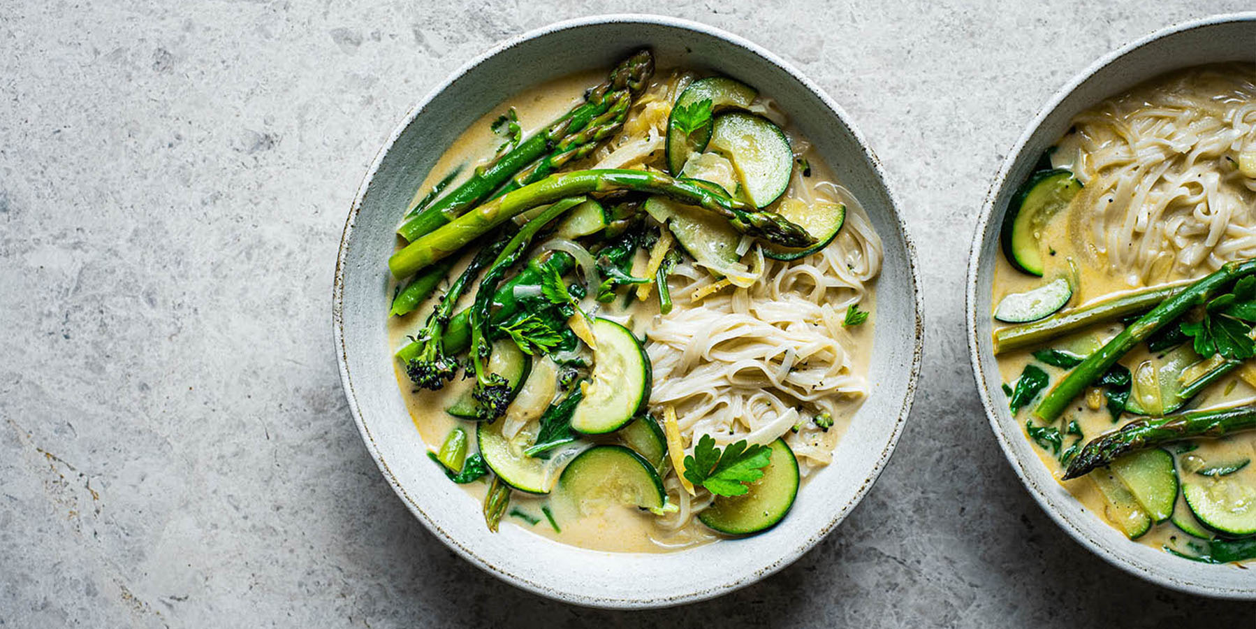Rice noodles with green vegetables in bowls.